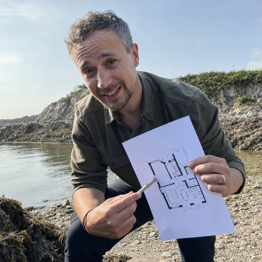 Adam Mokhtar, founder of Diogel Architecture, on the North Wales coast with a house floor plan